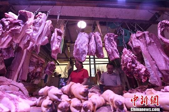 9月4日，重庆主城区的一家农贸市场内，商贩正在摆放猪肉。(资料图片)<a target='_blank'  data-cke-saved-href='http://www.chinanews.com/' href='http://www.chinanews.com/'>中新社</a>记者 陈超 摄